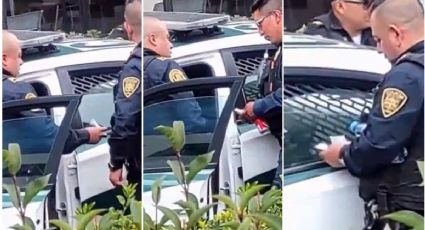 Policías de la CDMX son captados en video repartiendo fajos de dinero