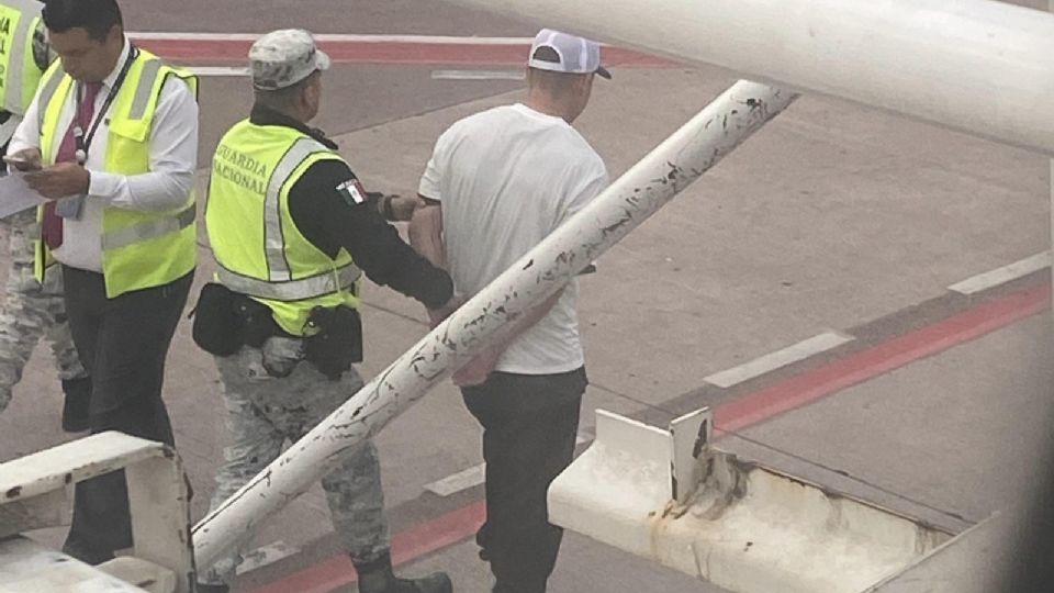 El hombre que intentó secuestrar el avión siendo detenido por autoridades.