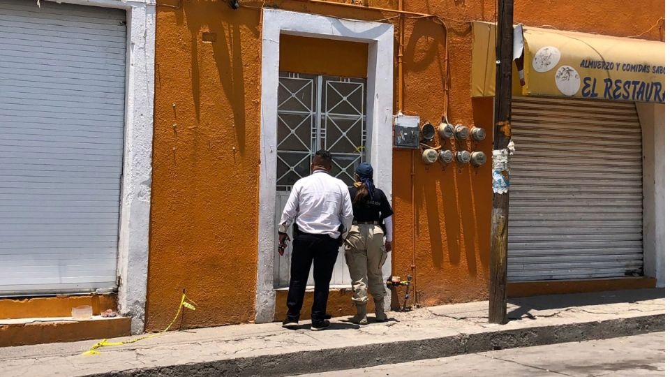 Dos agentes ministeriales tocan la puerta del número 405 vivienda en donde la noche anterior fueron asesinados 4 mujeres y 2 niños