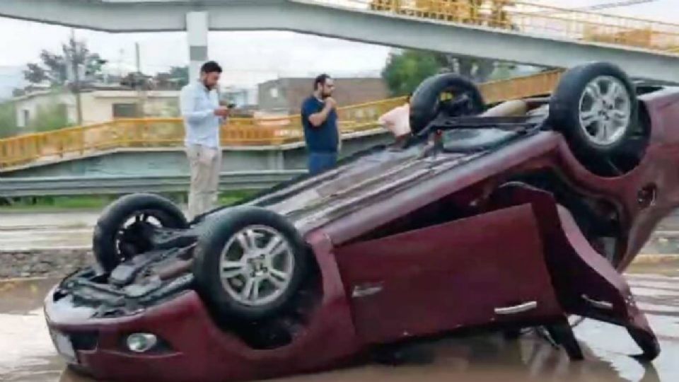 El vehículo quedó sobre el toldo después de que el conductor perdiera el control de la unidad una vez que pasara por un gran charco provocado por las intensas lluvias en la ciudad.