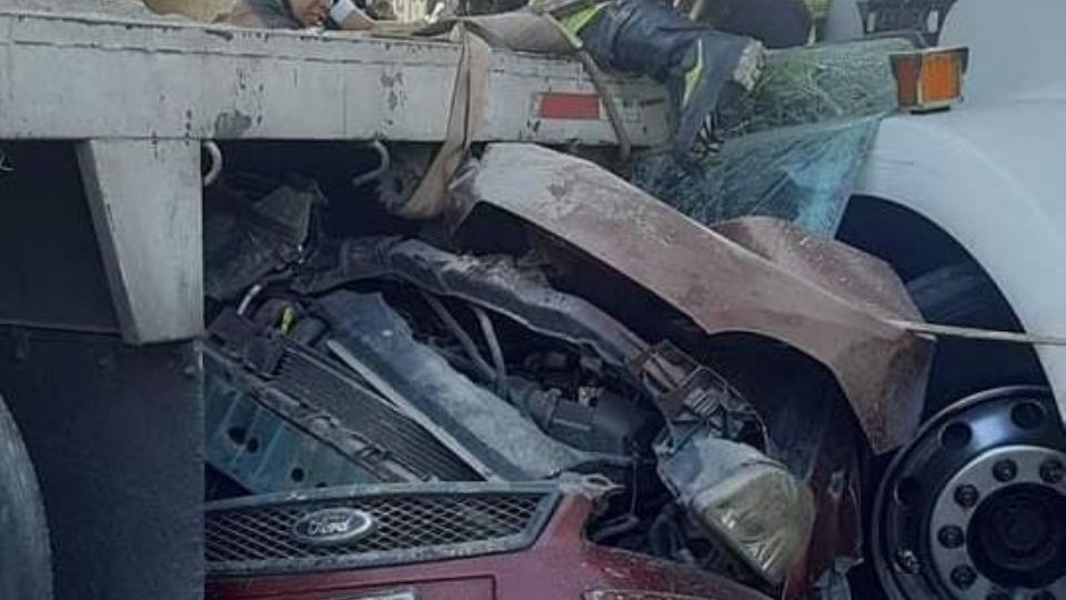 Un tráiler y un camión cargado con materiales de construcción chocaron entre sí, alcanzando al auto compacto Ford color rojo en la carretera México-Querétaro.