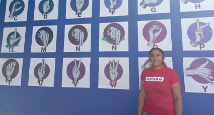 Maestra pinta mural con Lengua de Señas en escuela de Coatza