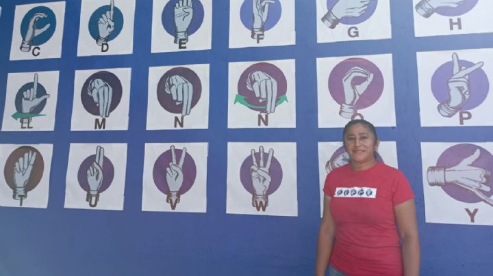 Maestra pinta mural con Lengua de Señas en escuela de Coatza