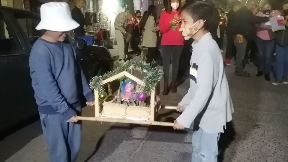 Niños cargan a los peregrinos en la tradicional posada de la calle Prado, en el centro de León.