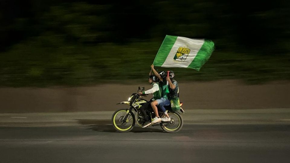 El equipo León fue campeón de la Concachampions, tres aficionados  se dirigen al estadio ondeando su bandera a toda velocidad abordo de una moto