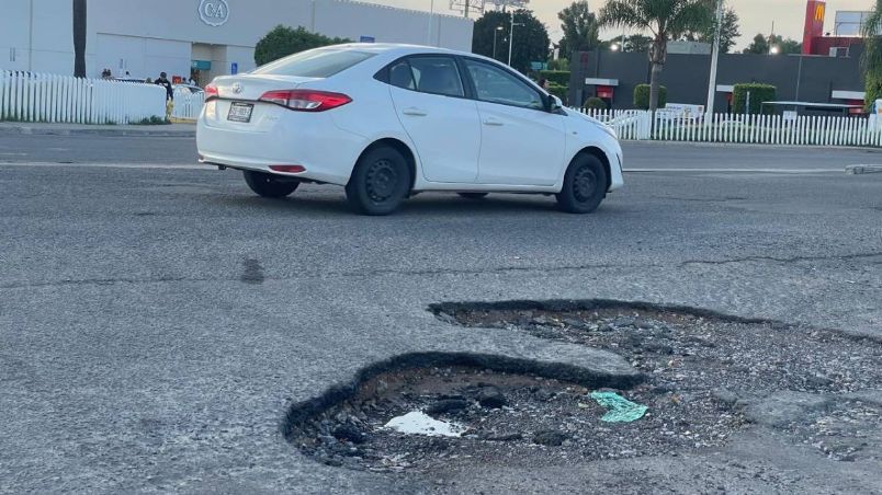 Un enorme bache en el estacionamiento de Centro Max es un dolor de cabeza para los conductores que llegan a la plaza.