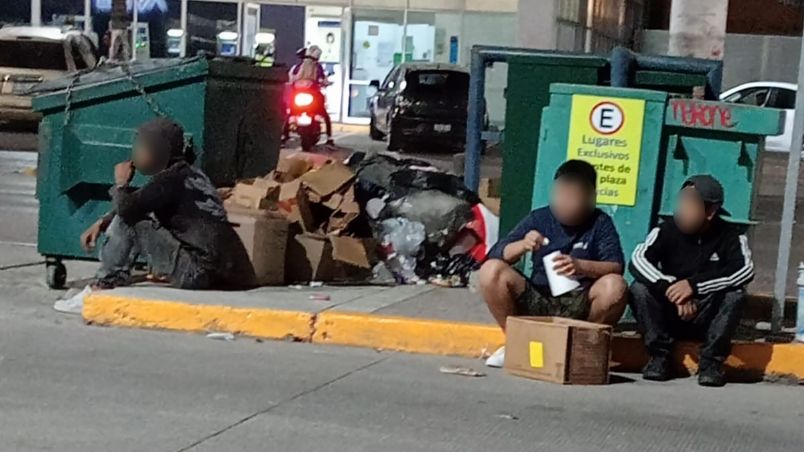 Unas pocas personas siguen esperando por restos de pizza afuera de Little Ceasars