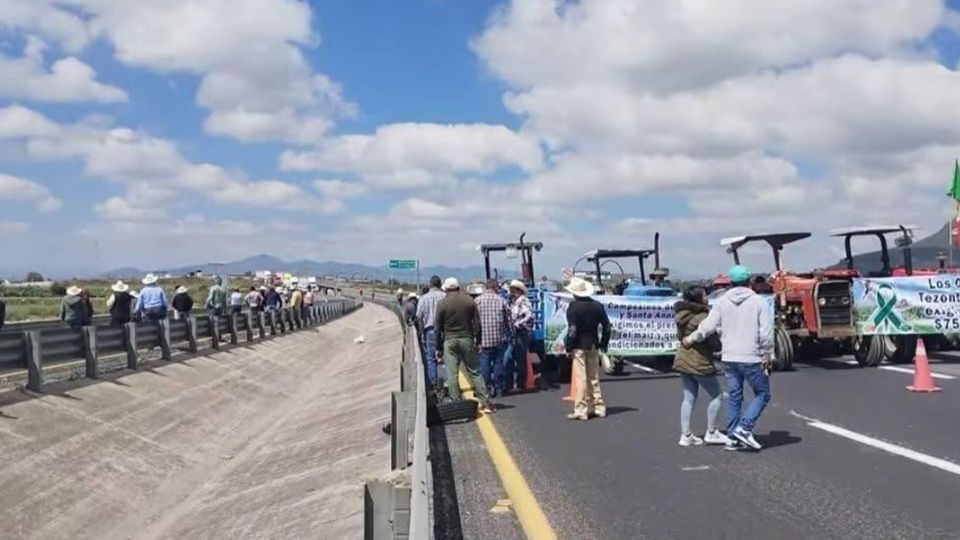 Son varias docenas de agricultores con sus tractores y maquinaria quienes bloquean la autopista