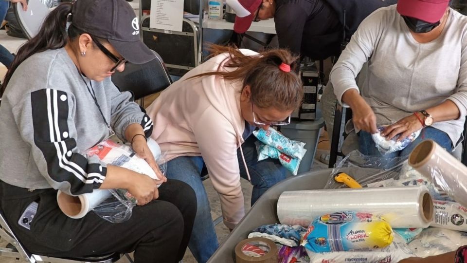 Voluntarios trabajan en el empaquetado de paquetes alimentarios para los habitantes de zonas afectadas por las lluvias
