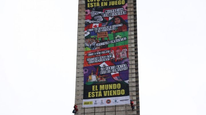 Amnistía y Greenpeace escalan la Estela de Luz con manta con mensajes sobre migración y justicia